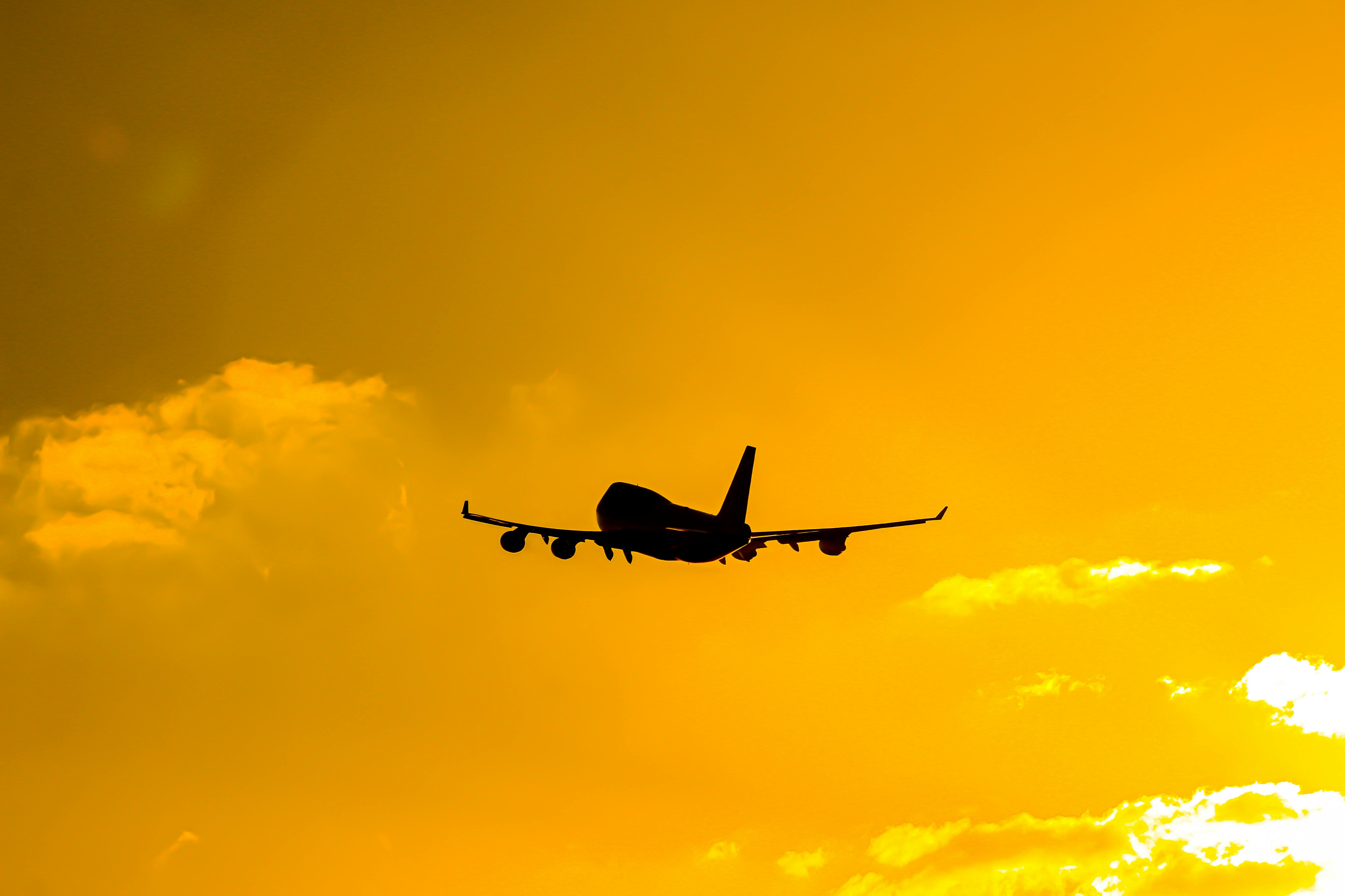 צללית מטוס בשמי שקיעה זהובים | Airplane Silhouette in Golden Sunset Sky